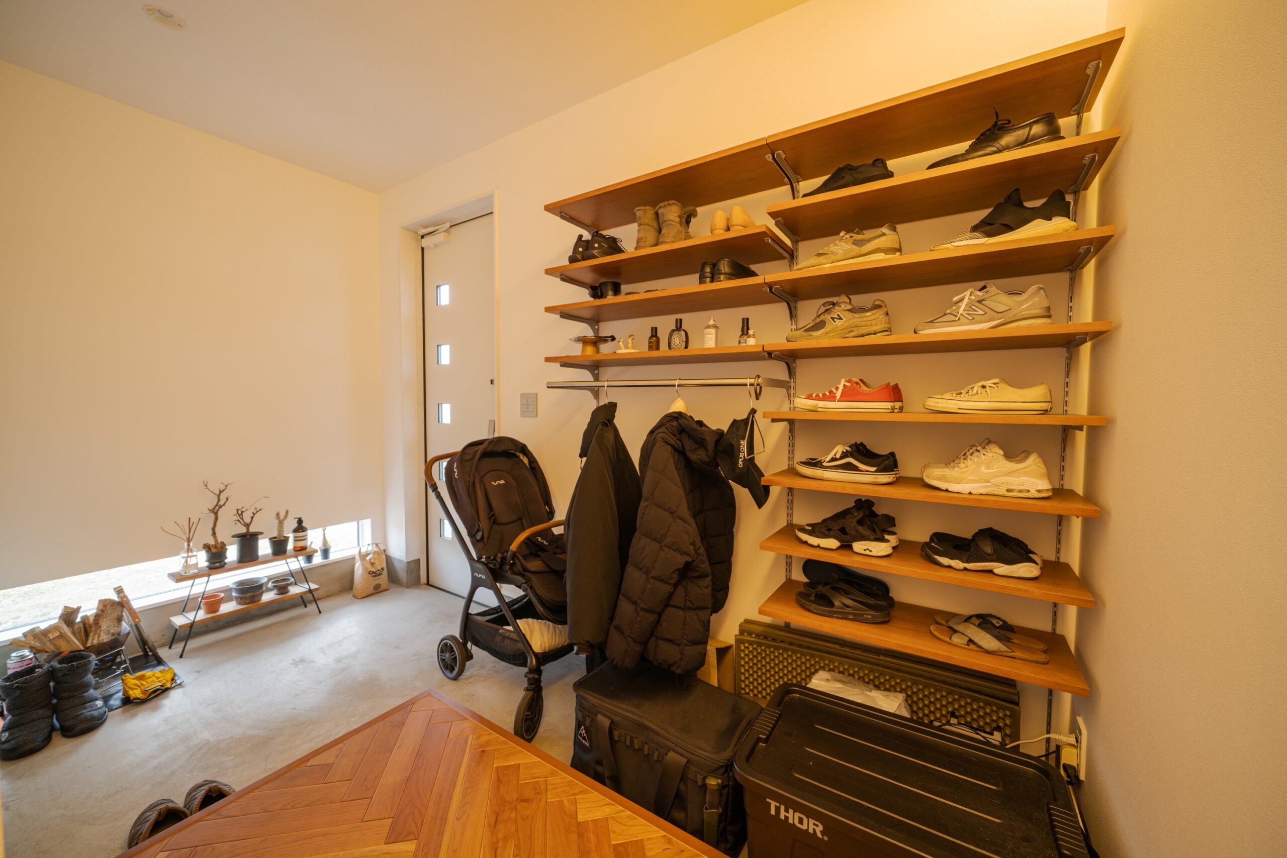壁一面に設置された木製の可動棚には、お気に入りの靴や小物を「見せる収納」としてレイアウト可能です 。
