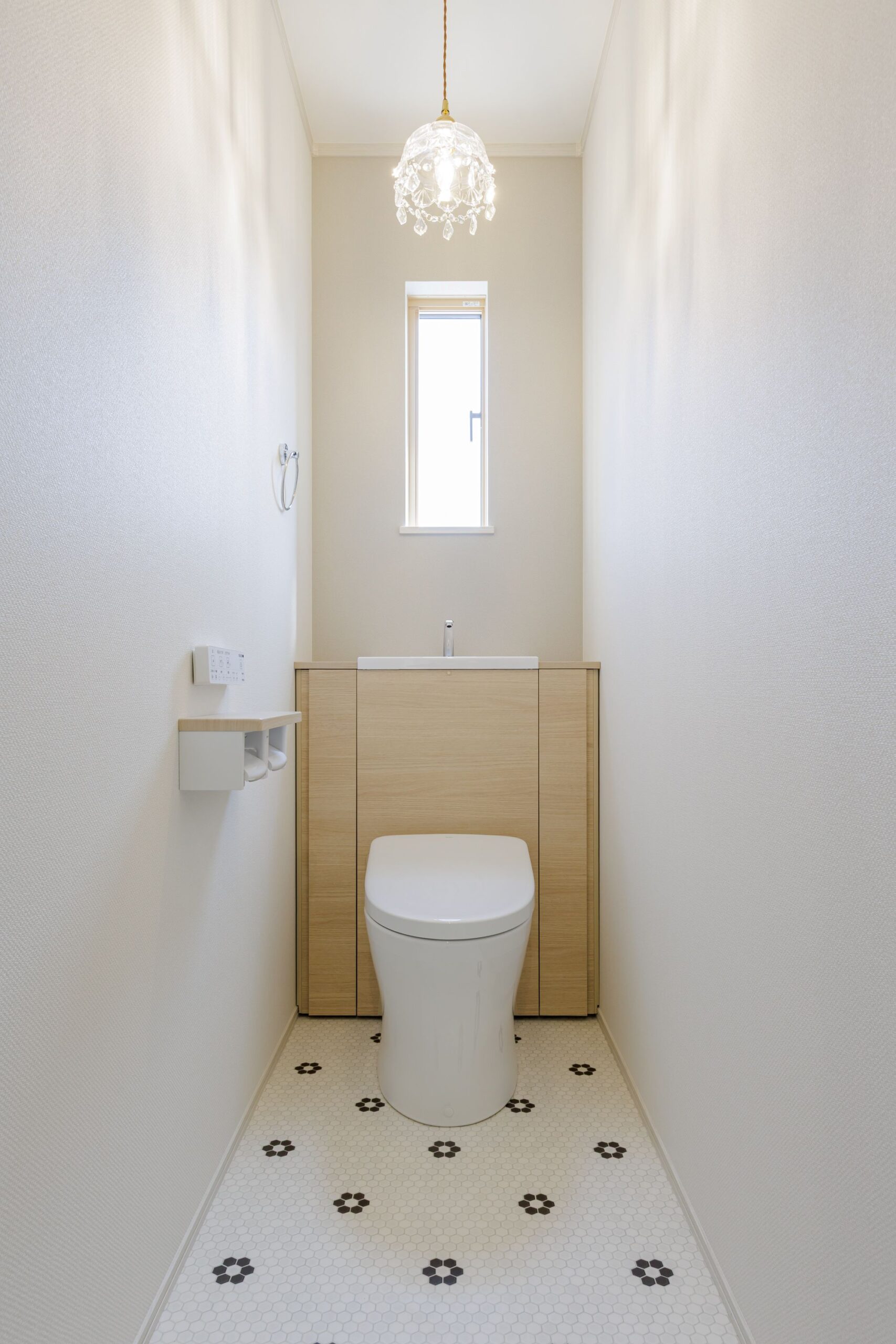 お花のようなタイル柄の床と、クリスタル調のペンダントライトが主役。落ち着いたベージュのアクセントクロスで、上品かつ可愛らしい雰囲気に仕上げました。